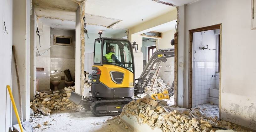 Escavatore elettrico al lavoro in una demolizione in interni