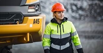 En operatør står ved siden af fronten på en A45 Volvo rammestyret dumper.
