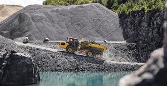 En rammestyret Volvo A50 dumper med fuld affjedring, som kører på en grusvej i et stenbrudsmiljø