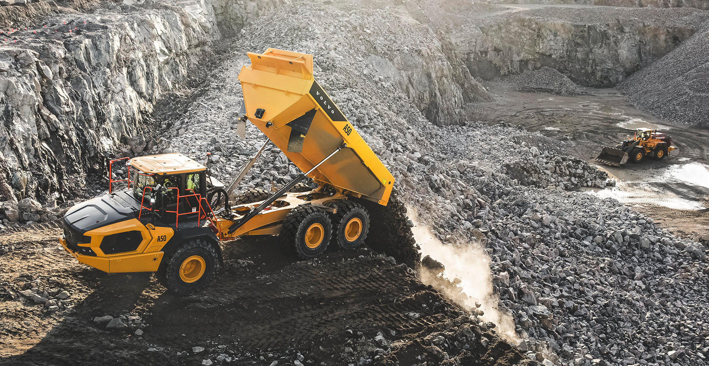 Volvo A50 full suspension articulated hauler empties a material load in a quarry environment