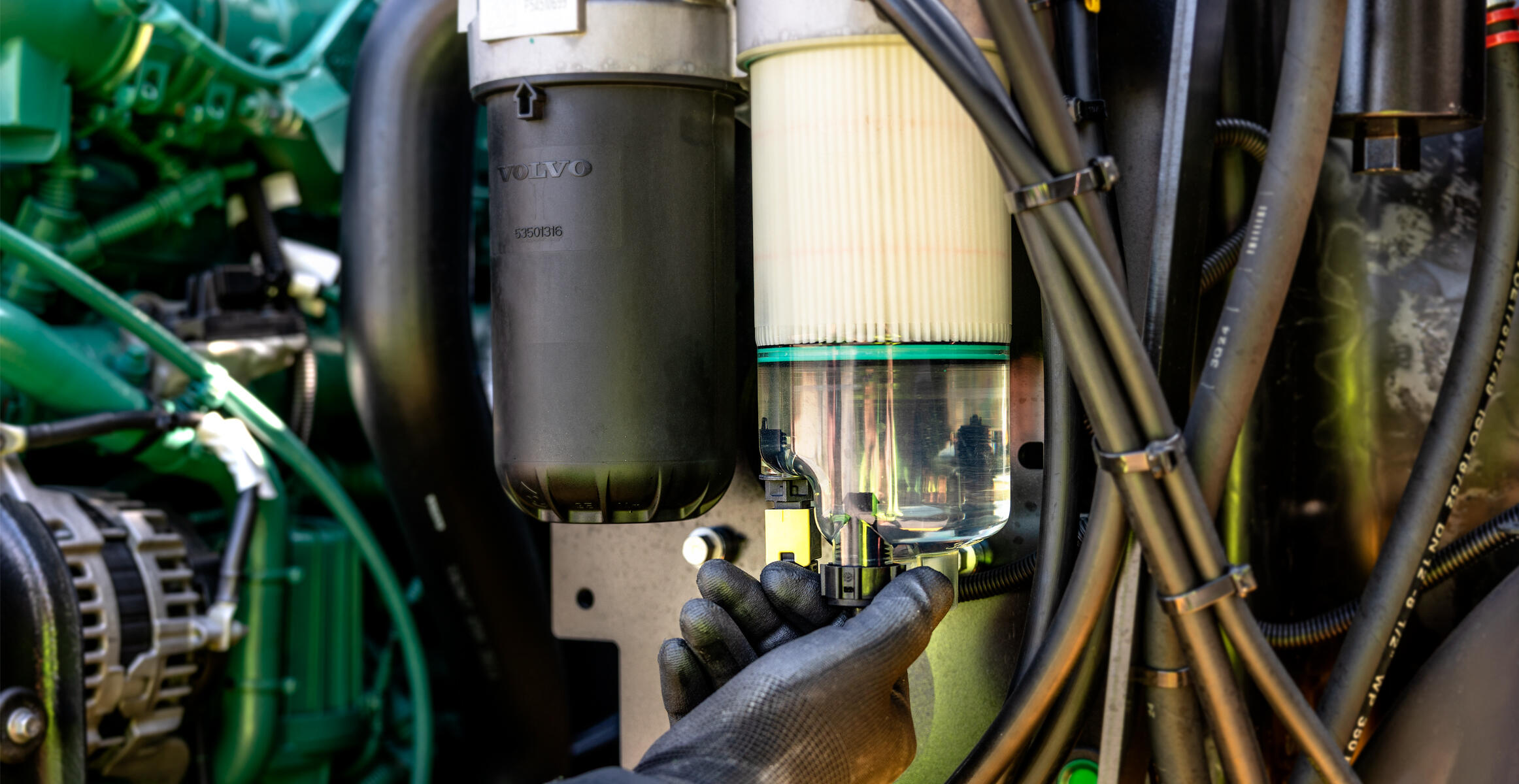 A close-up of a fuel filter water separator system on a Volvo articulated hauler
