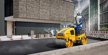 Side view of an operator compacting the asphalt in a street city