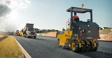PT125C  asphalt compactors finishing the asphalt surface in front of truck and a paver