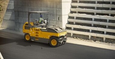 Side view of the Volvo PT220 tyre roller passing under a bridge on an highway