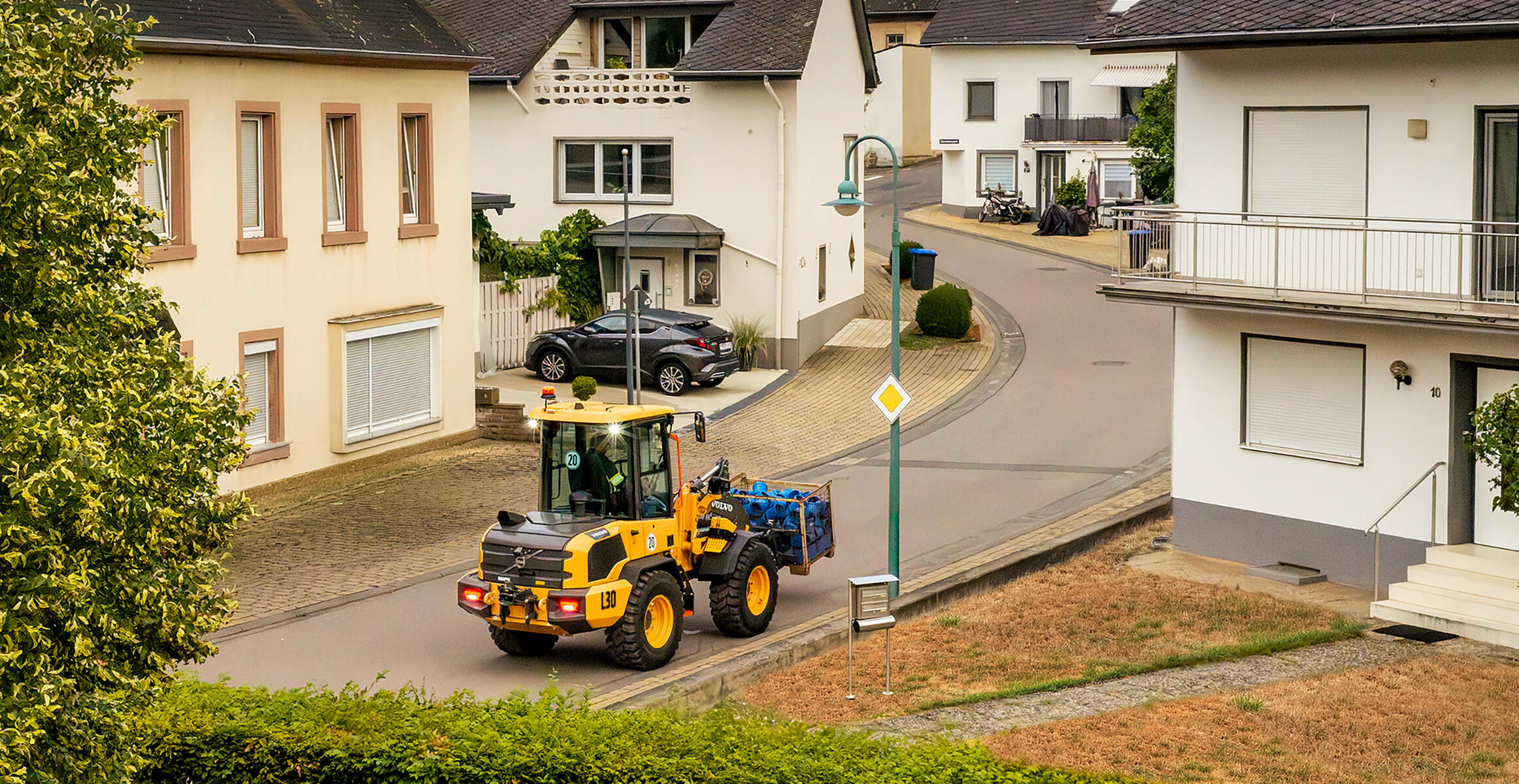 Volvo L30 Compact Wheel Loader working in a confined residential jobsite.