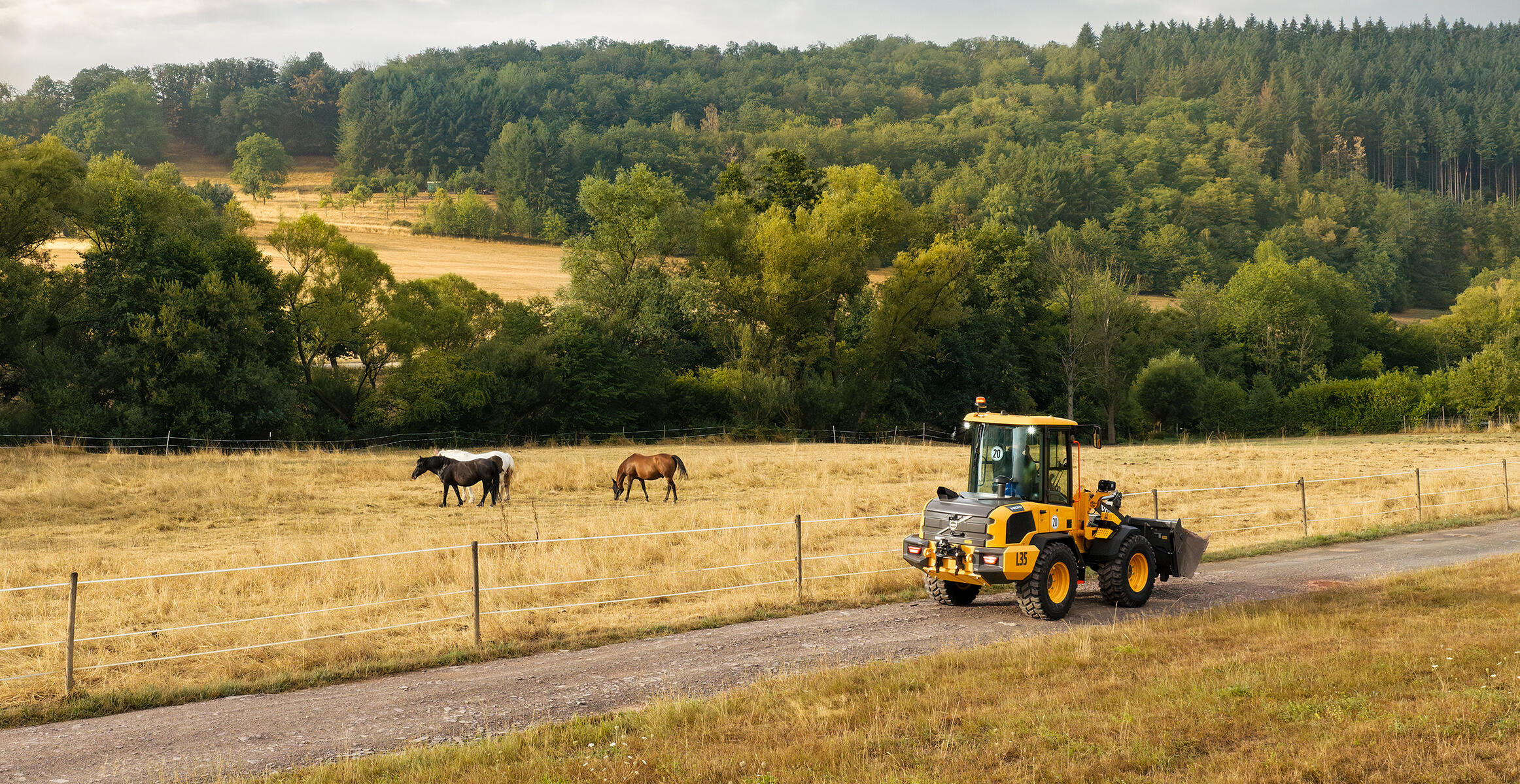 Volvo L35 Compact Wheel Loader operating on a rural jobsite beside a pasture.