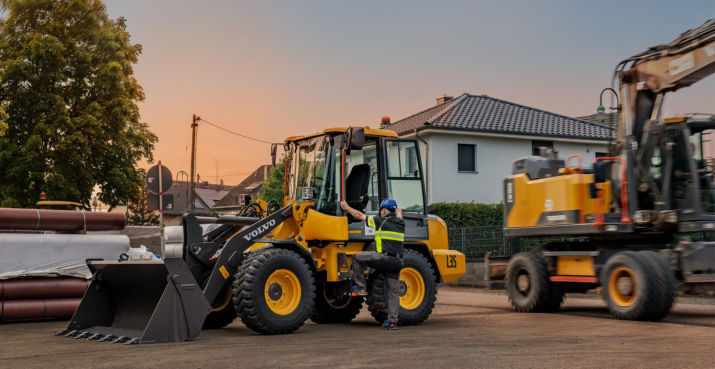 Volvo L35 Compact Wheel Loader operating in a construction yard with another loader nearby.