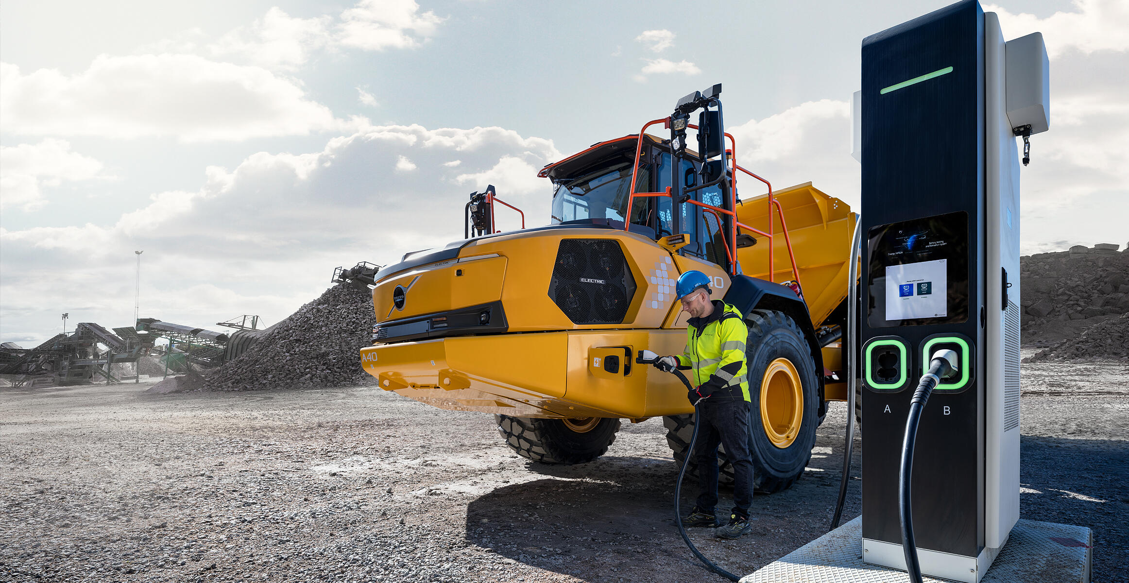 En person som startar laddningen av den nya eldrivna ramstyrda dumpern Volvo A40