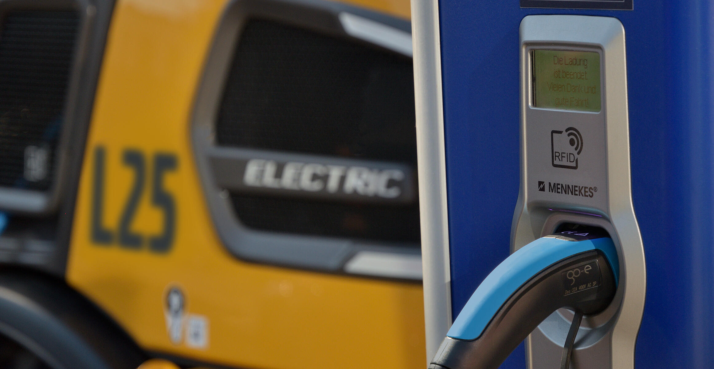 Zbliżenie na przewód ładowania podłączony do elektrycznej kompaktowej ładowarki kołowej L25 Electric