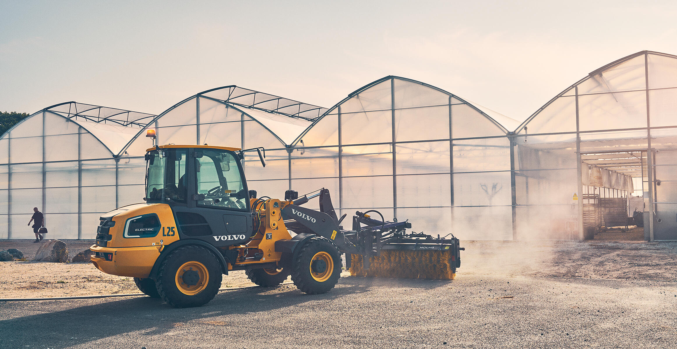 Elektryczna kompaktowa ładowarka kołowa L25 Electric zamiatająca teren przed szklarniami