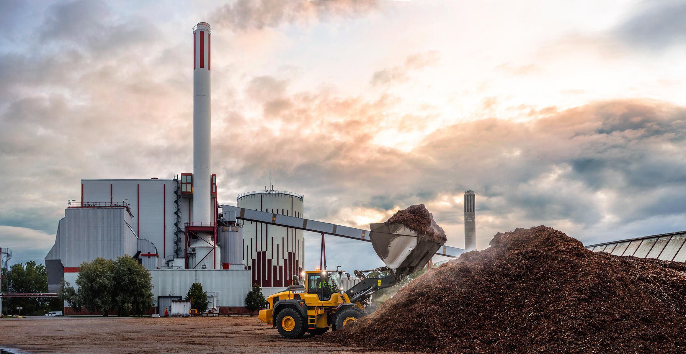 A Volvo L110Hor L120H wheel loader in action in a waste or recycling site.