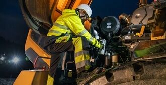 Volvohjullastare som ges service av tekniker på natten