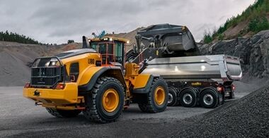 Volvo L180-hjullastare lastar en Volvolastbil i en bergtäkt