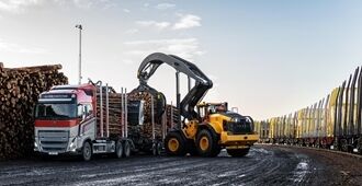 Hjullastaren Volvo L200 High Lift lastar timmer på en lastbil vid timmerhantering