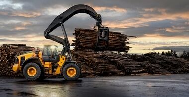Timmerlastaren Volvo L200 High Lift med lyftarm och grip som bär en last av timmerstockar