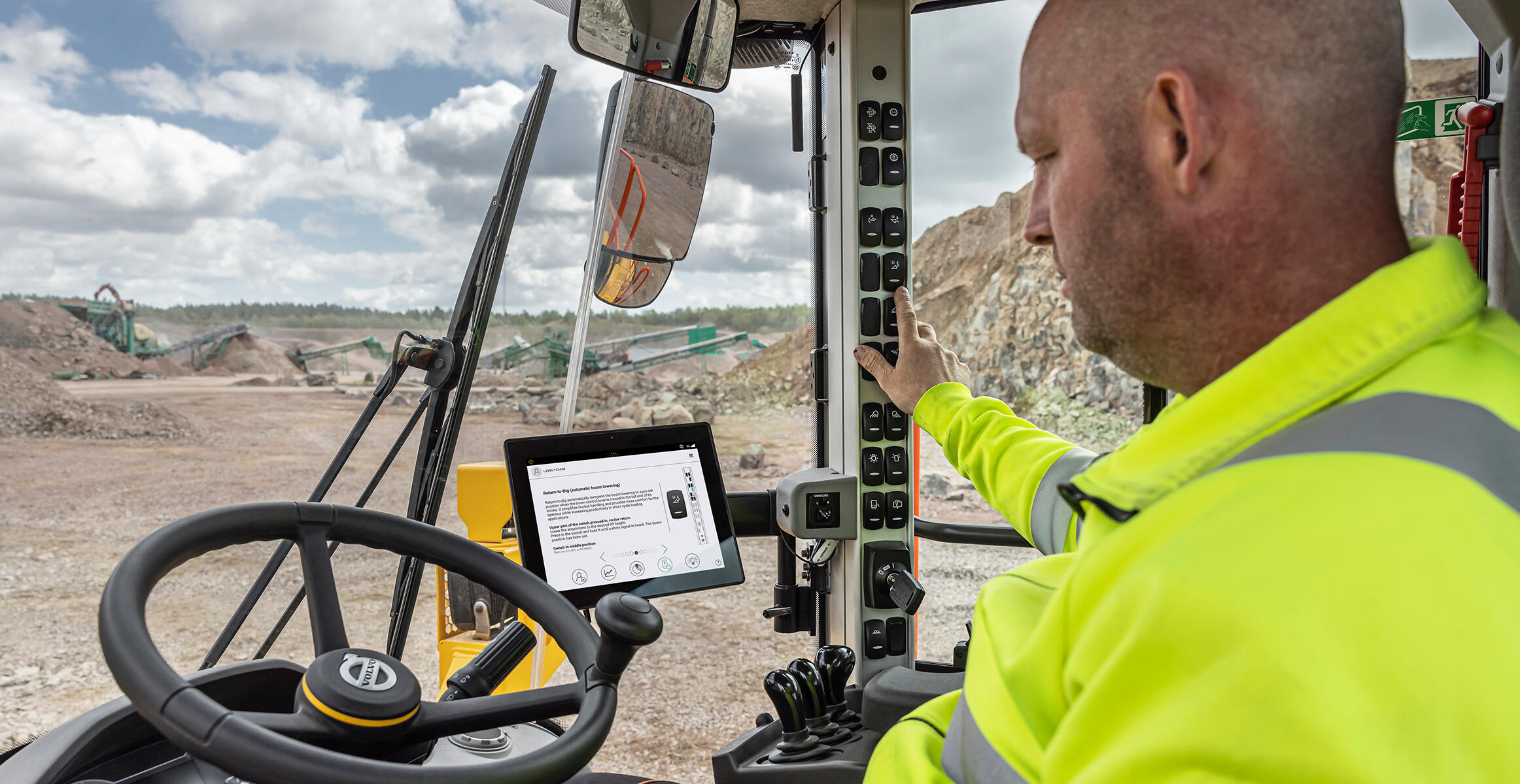 An operator switching on the fuel efficiency mode on a L350H wheel loader.