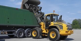 The Volvo L45H performing loading or lifting operations in an industrial environment with Tp-linkage.