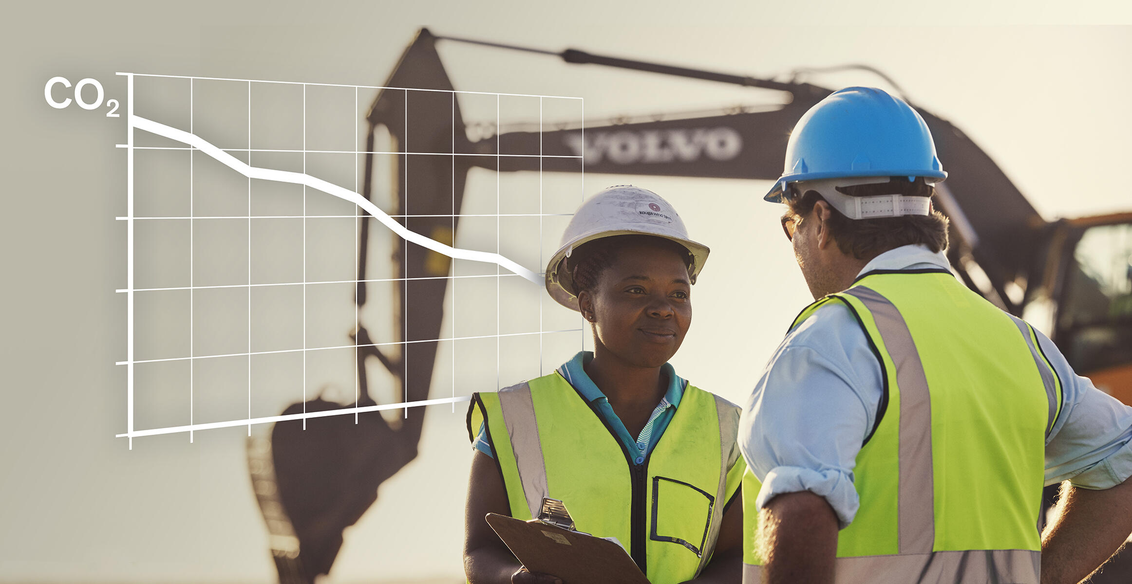 Workers discussing near Volvo excavator with decreasing CO2 emissions graph overlay