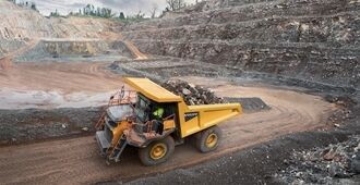 Side view of a Volvo R70 mining truck loaded with rock blocks.