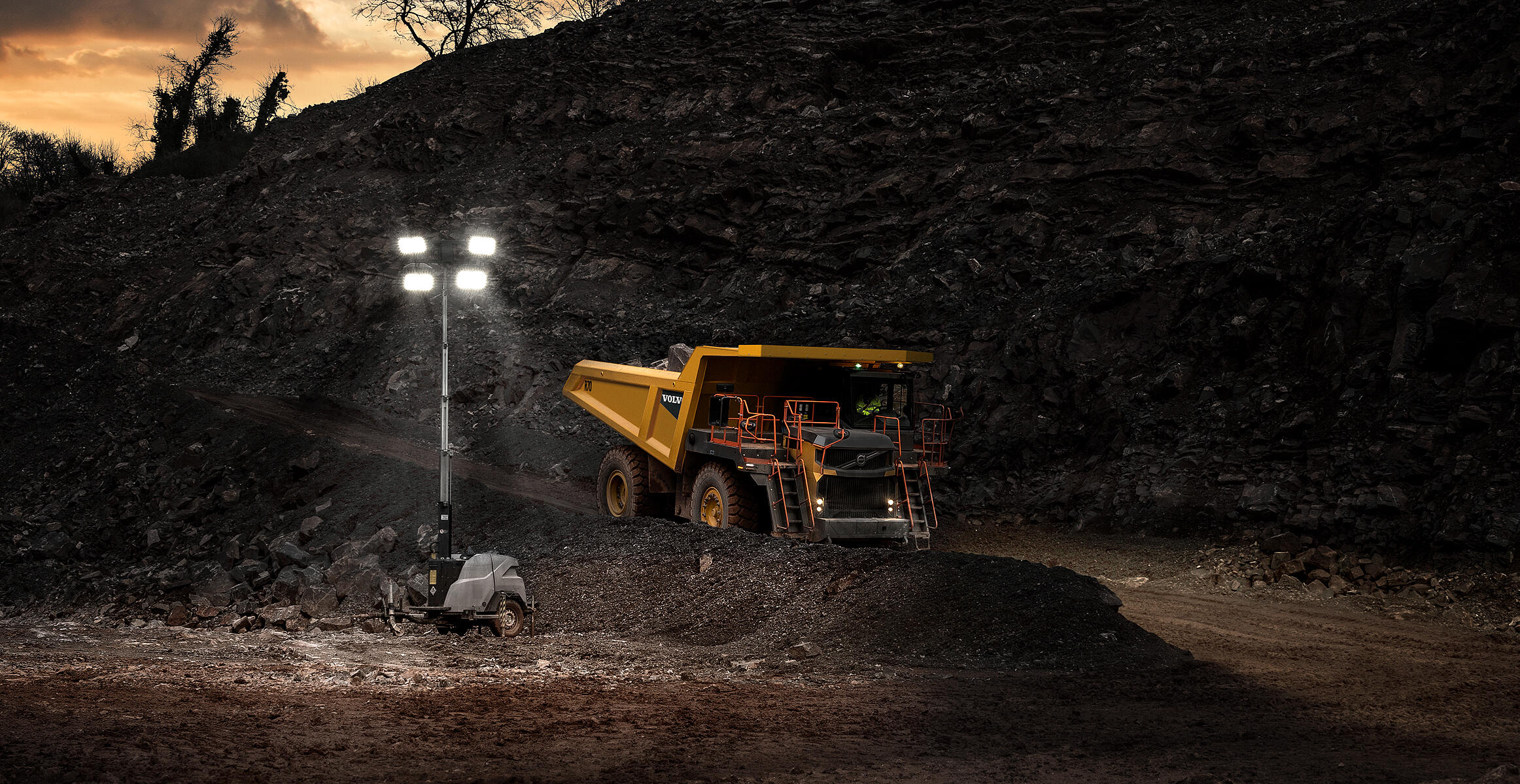 Wozidło sztywnoramowe Volvo R70 zjeżdżające ze zbocza w ciemności.