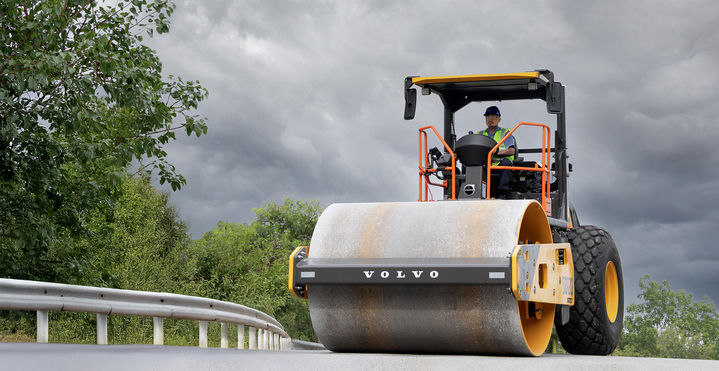 Front view of Volvo SD120 soil compactor on a flat road somewhere in Asia.