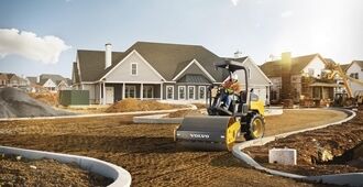 A front view of a Volvo SD45B soil compactor compacting in small spaces in a residential site