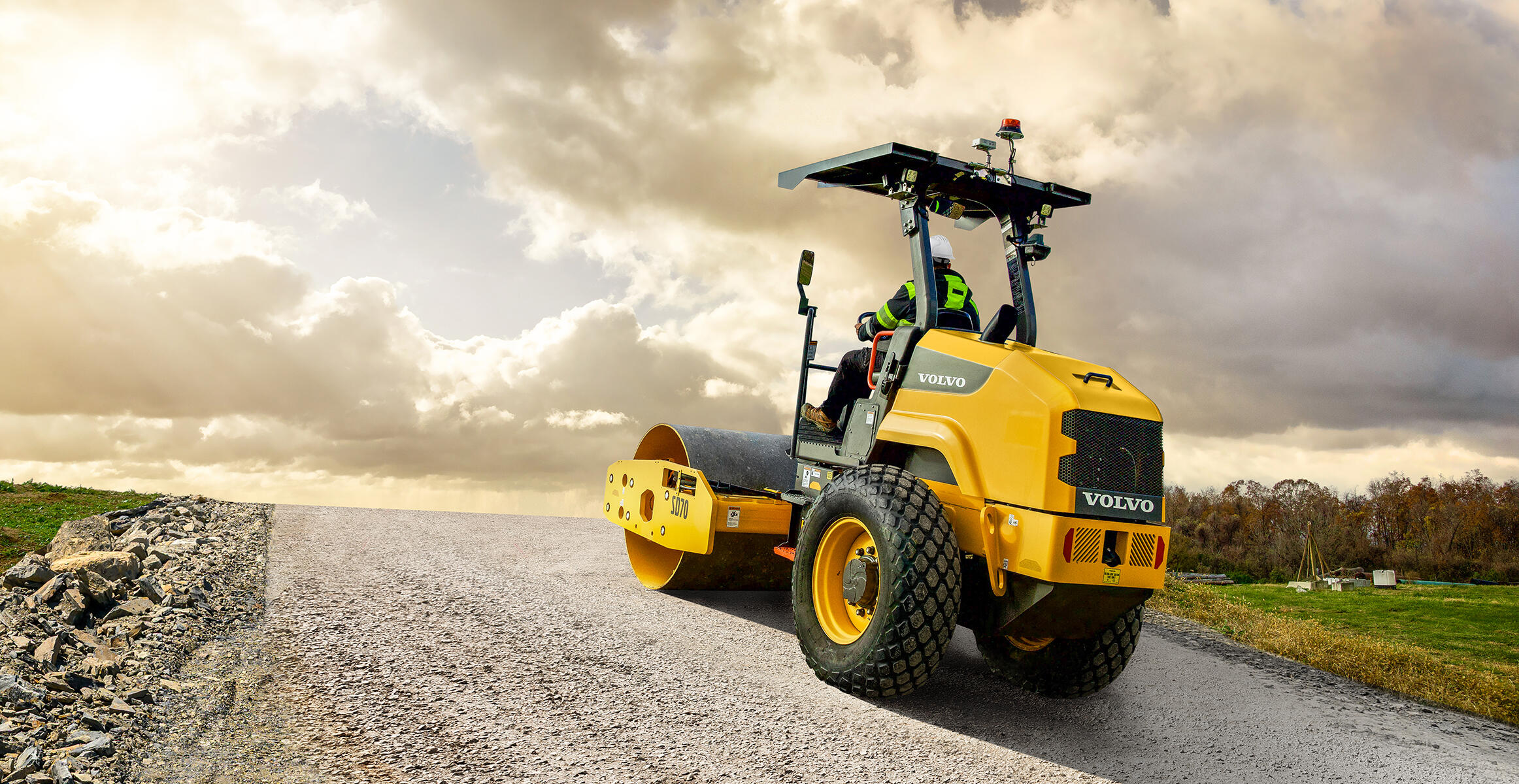 Volvo SD70 compacting a gravel surface under bright sunlight