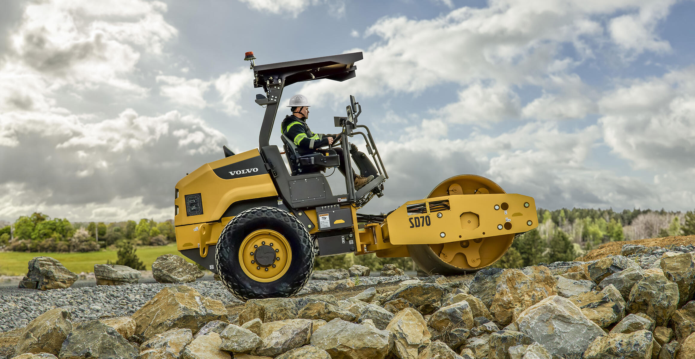 Side view of the Volvo SD70 climbing a slope while compacting soil