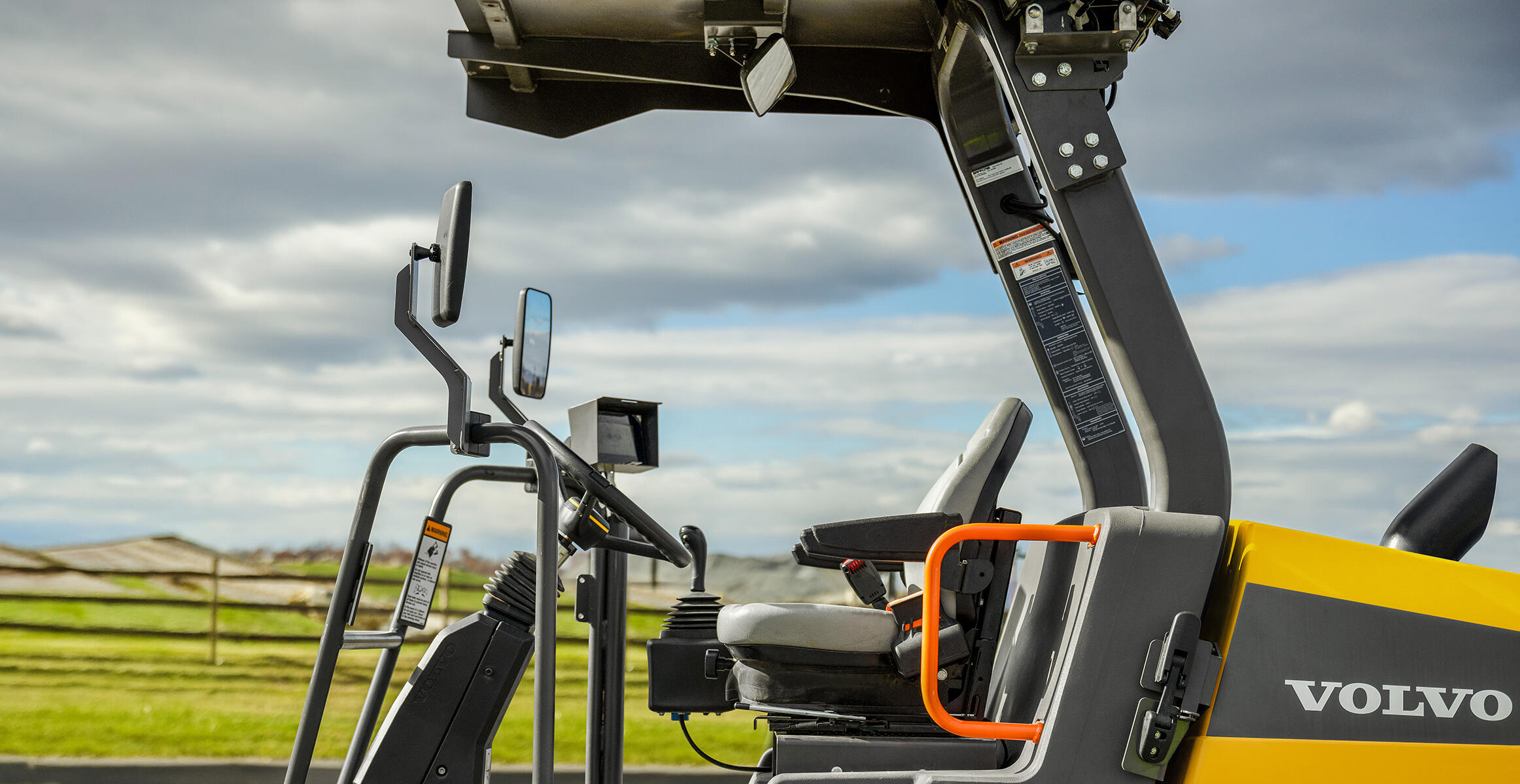 Side view of the Volvo SD70 cab featuring orange handrails and ROPS protective roof