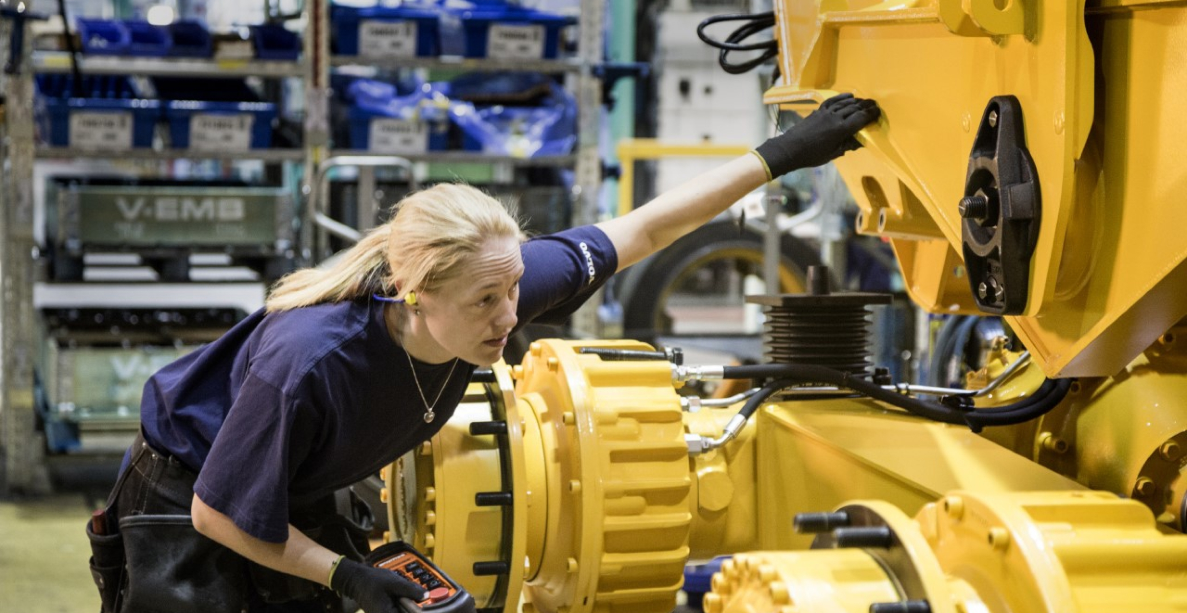 Woman inspecting machine in factory