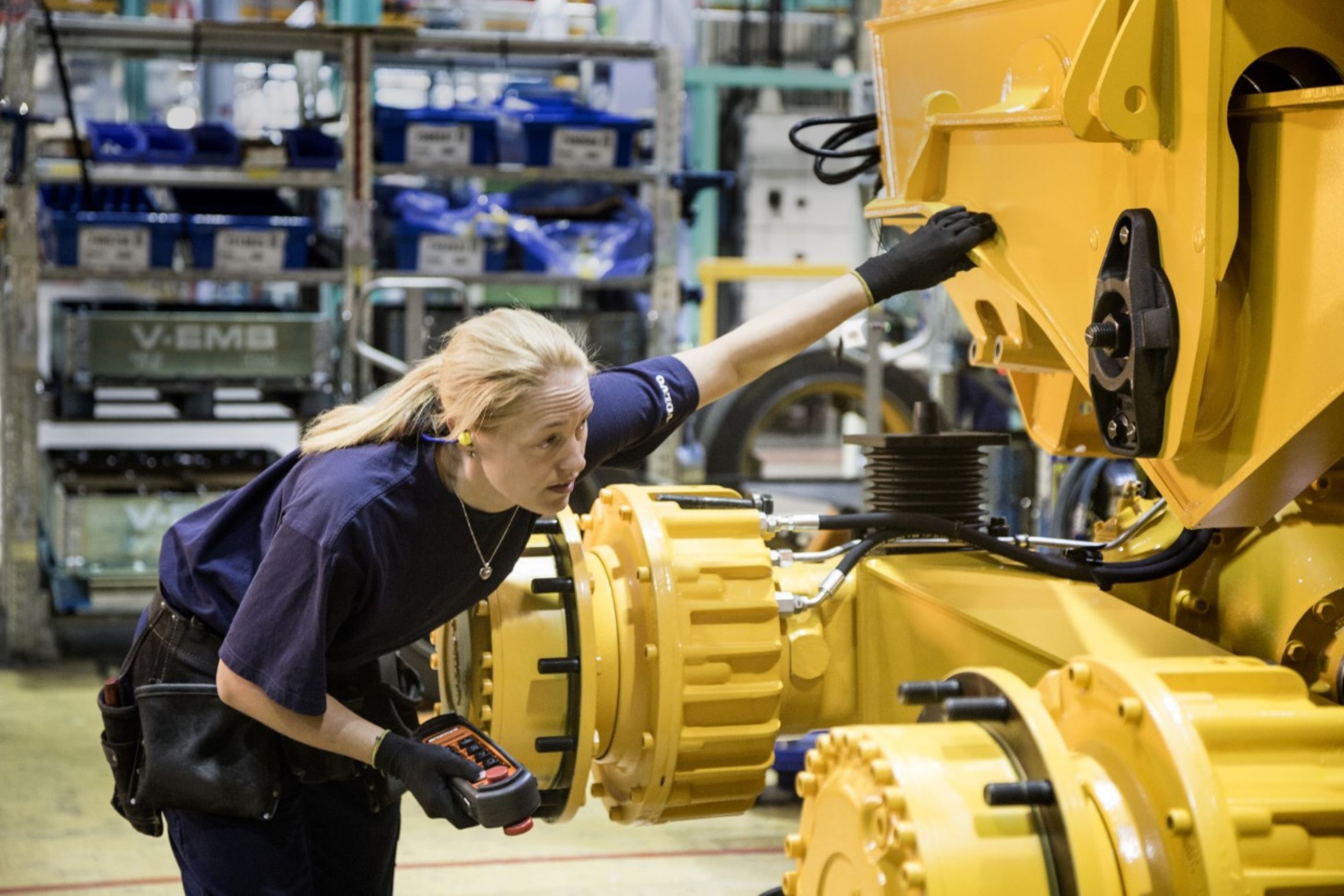 Woman inspecting machine in factory 