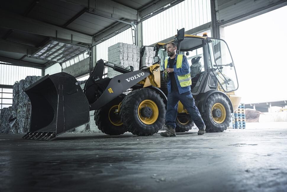 an operator standing outside the Volvo machine