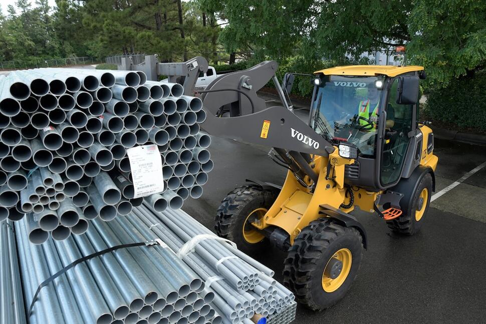 A Volvo L25 Electric wheel loader carrying pipes for the Kempower charging station build.