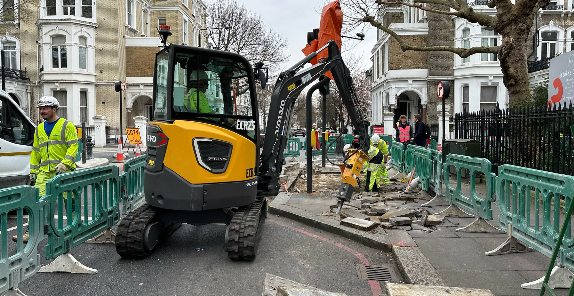 Electric excavator doing urban construction work in central London.