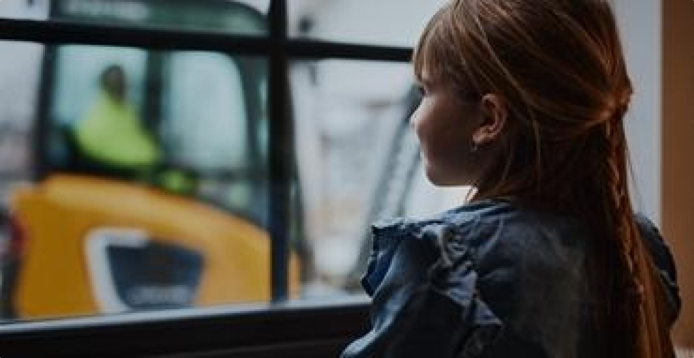 Girl looking at an electric excavator through a window