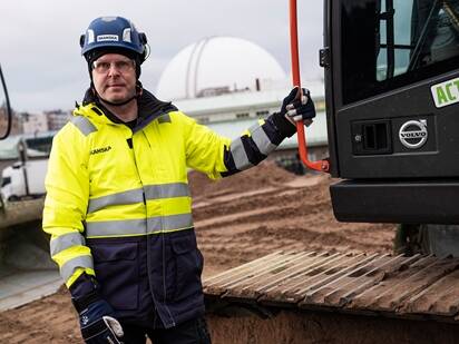 Electric excavator at Sweden’s largest fossil-free construction site Slakthusområdet with Skanska operator.