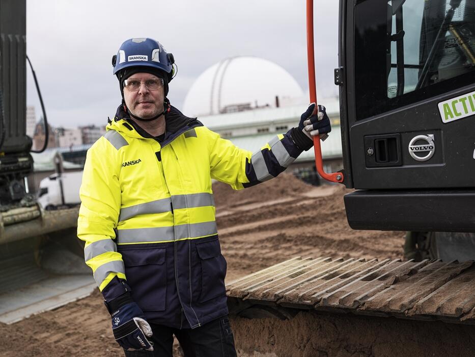 A Volvo operator standing in front of a Volvo machine