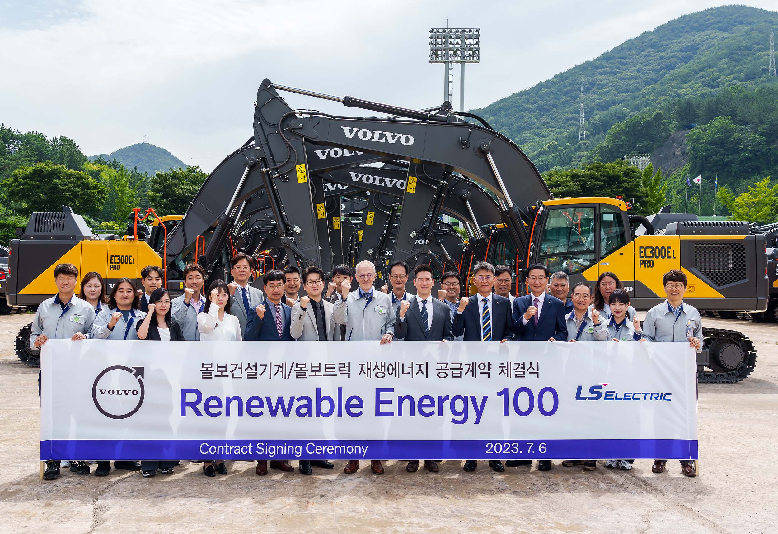 a group of people posing with the renewable energy 100 banner