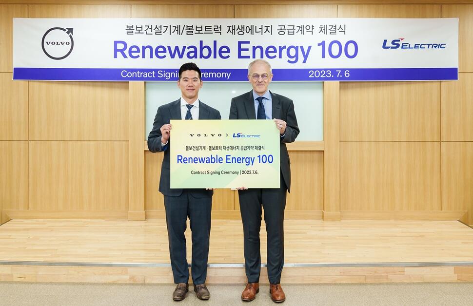 two men posing with the renewable energy 100 banner