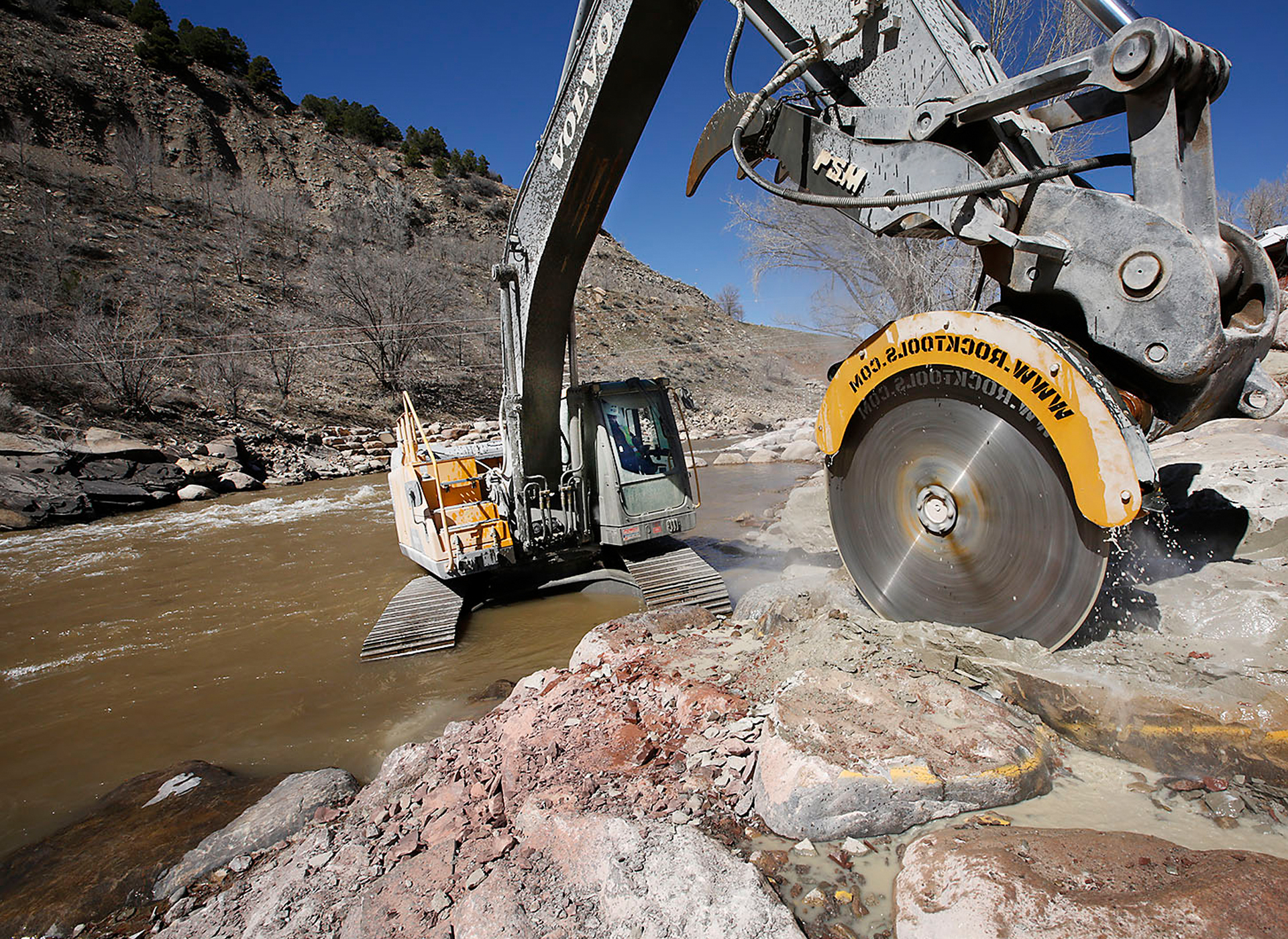 Volvo excavator saws through rock at Durango Whitewater Park in Colorado