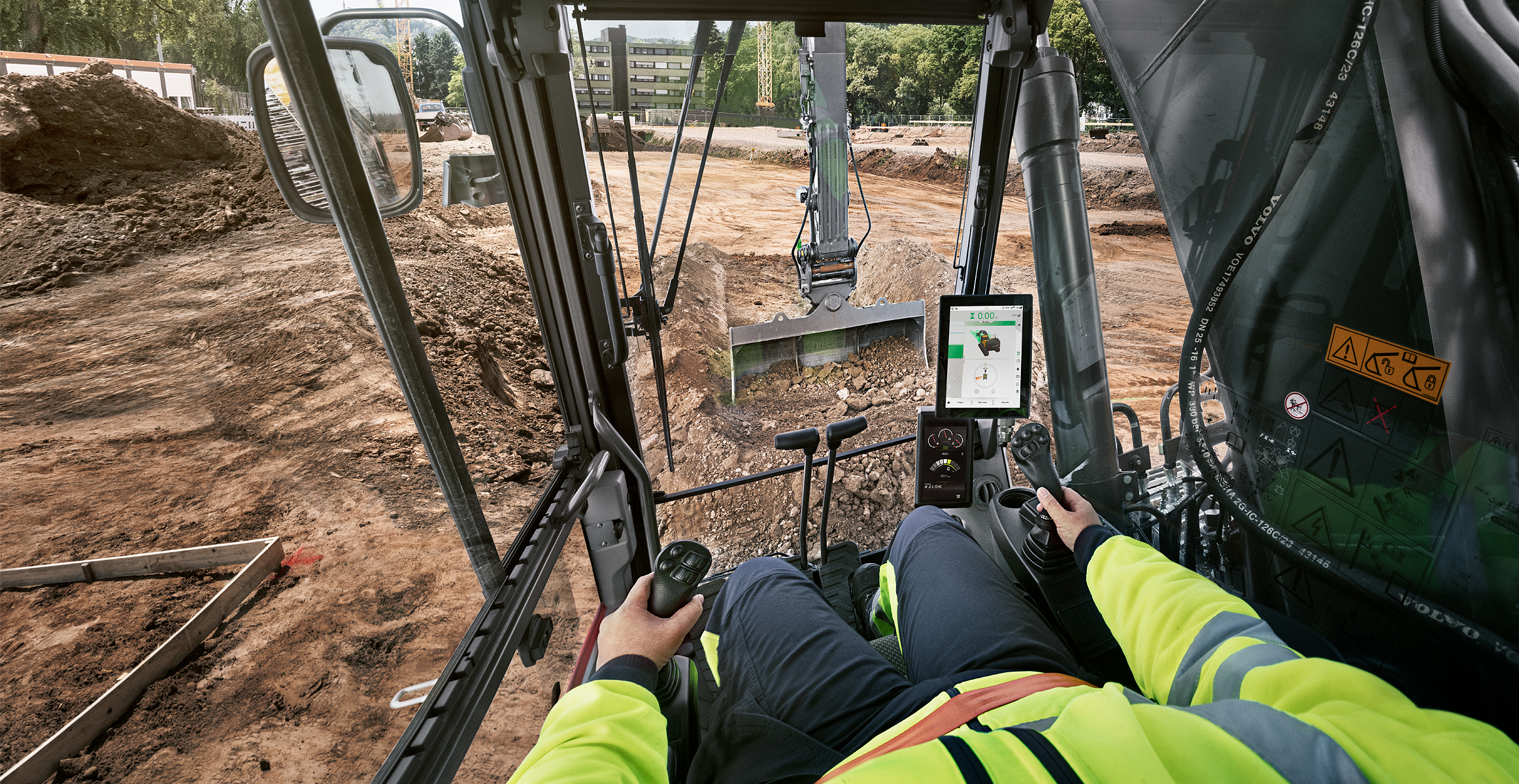 Electric excavator digging dirt from operator’s point of view.