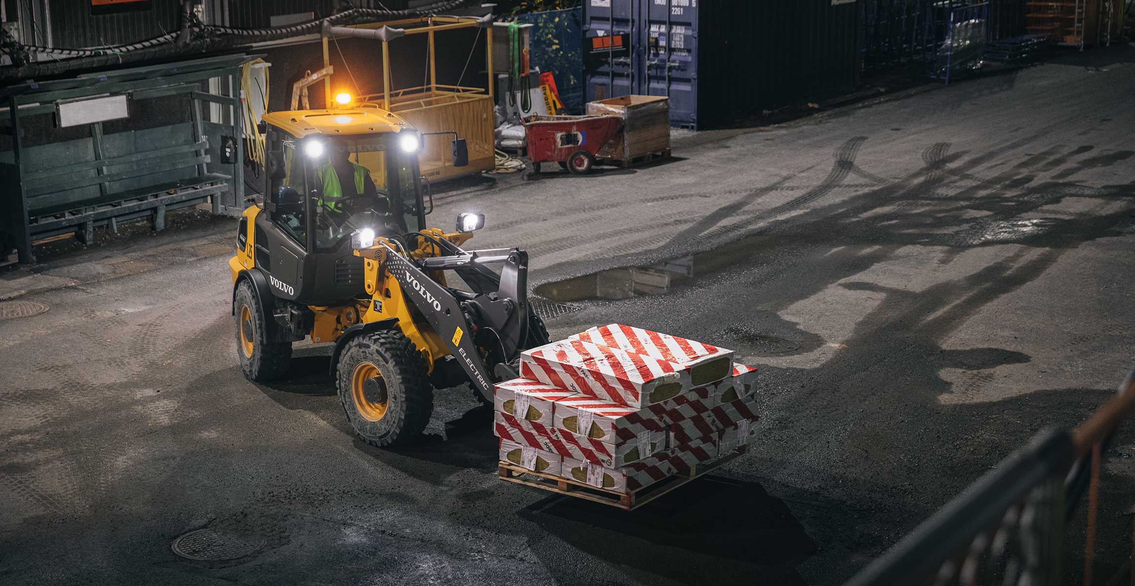 cargadora pequeña de construción elétrica con horquillas cargando material