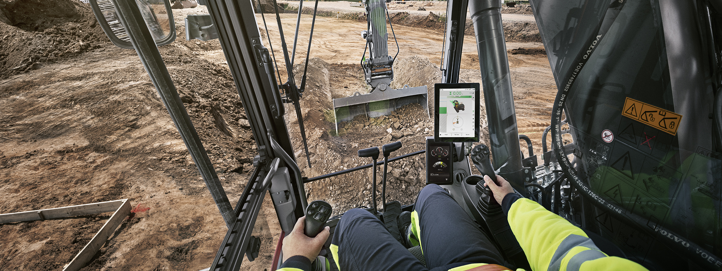 Operator's view from Volvo excavator cab with digital display showing worksite coordinates
