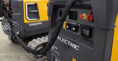 Close-up of a Volvo PU40 mobile power unit charging a Volvo electric mini excavator.