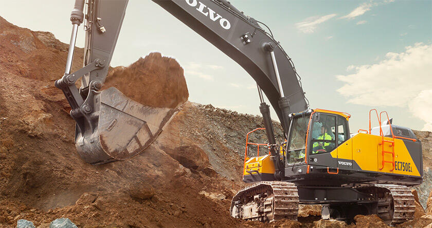 A Volvo EC750E excavator loading dirt with a bucket.
