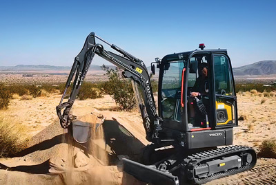 Volvo electric excavator lifting dirt on site