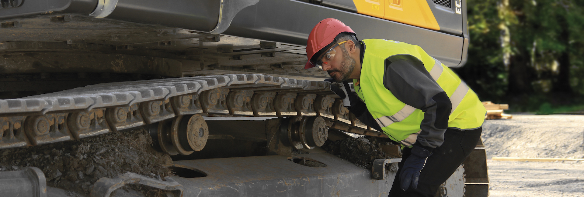 Man inspecting Volvo construction machine