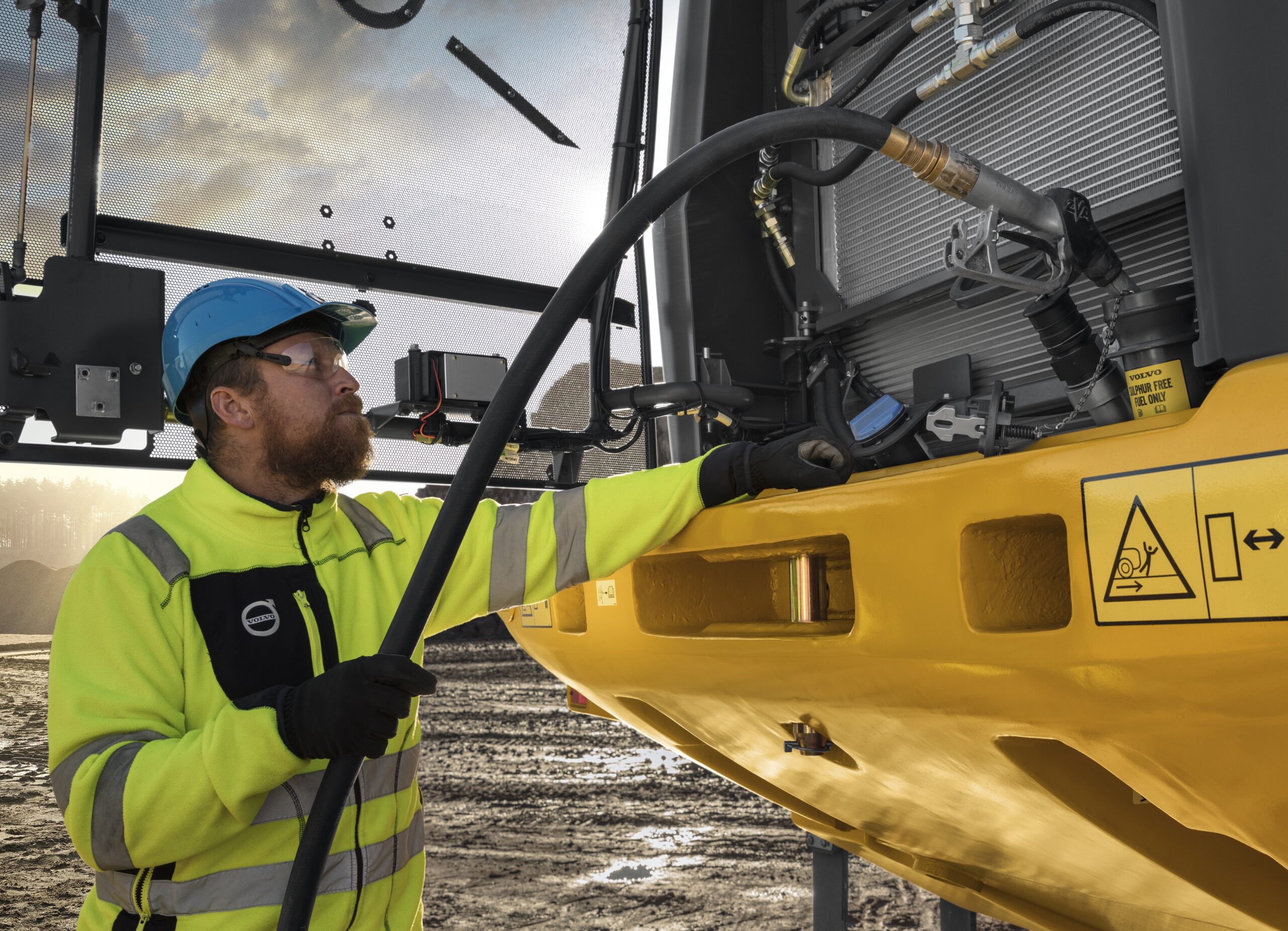 Man refilling fuel and DEF tank in Volvo machine