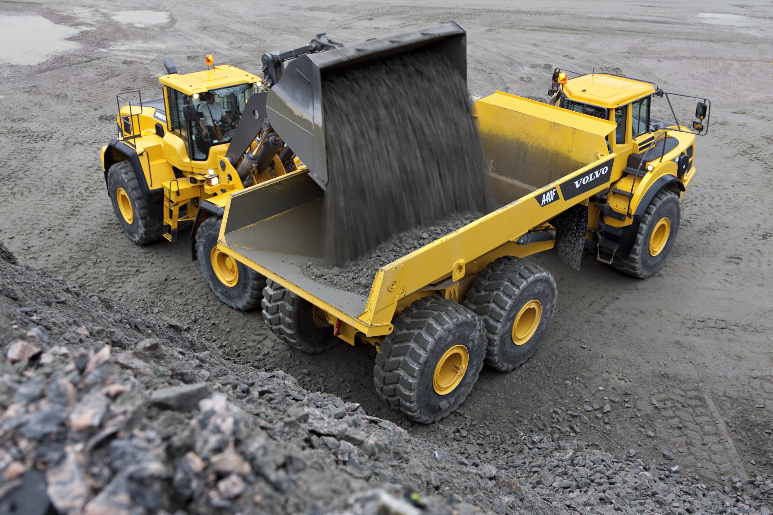 Volvo wheel loader emptying aggregate into a Volvo articulated hauler