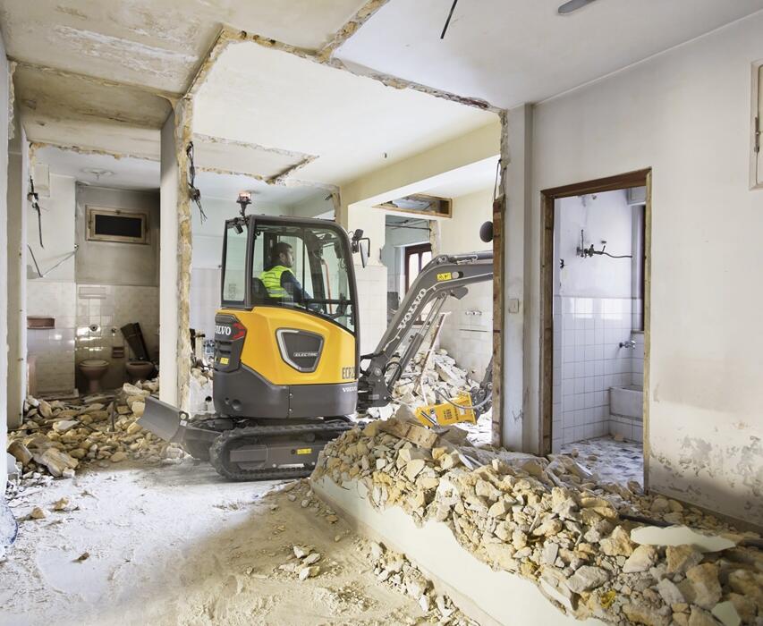 Photo of a compact Volvo electric excavator completing inside demolition.